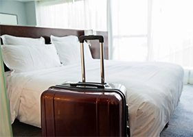 Landhotel Classhof Suite Koffer des Gastes mit Hotelbett im Hintergrung